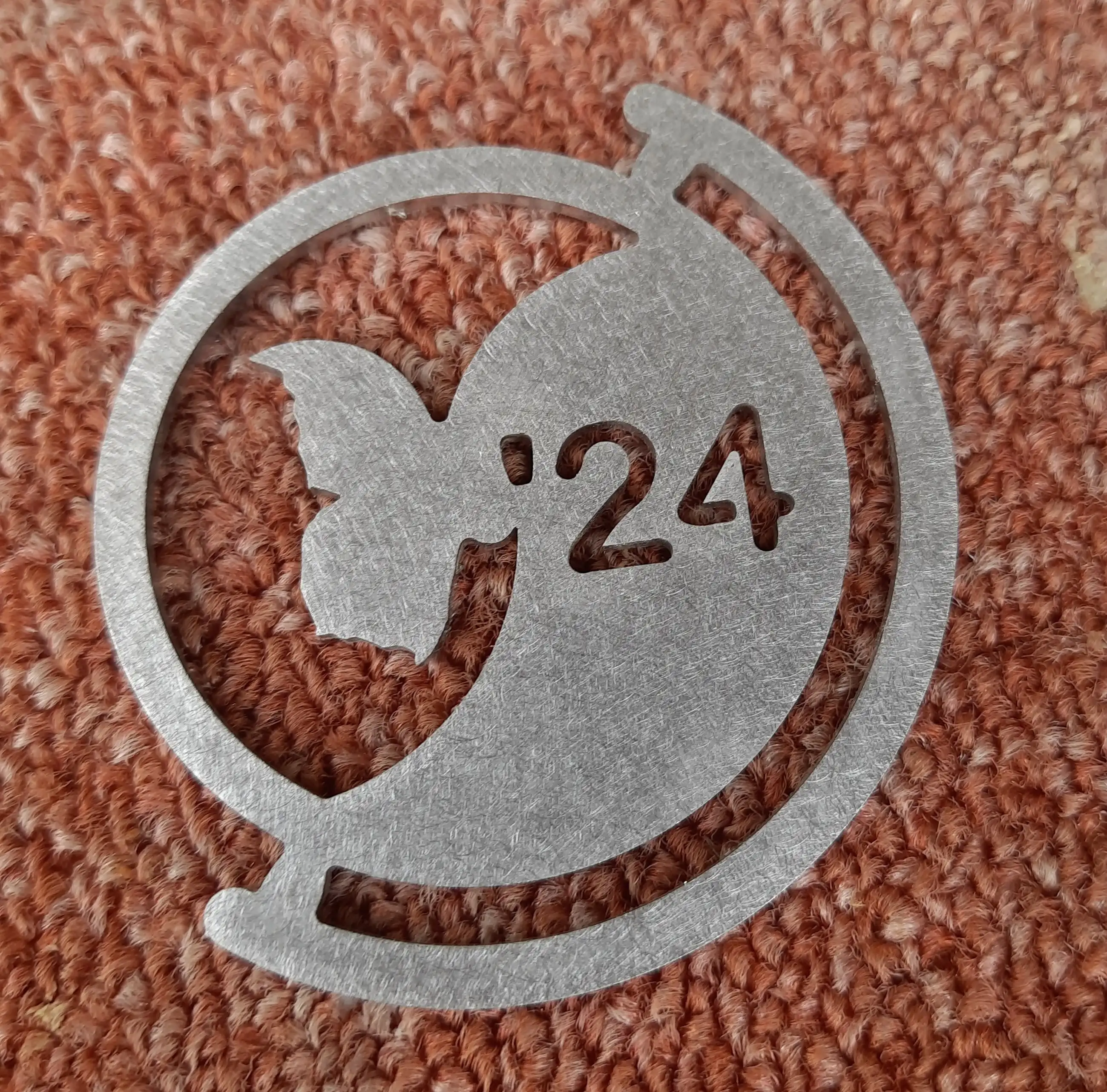 metalen sleutelhanger in roestvast staal-plaat van 2mm. Het logo is een vlinder van Gooikoorts Folkfestival.